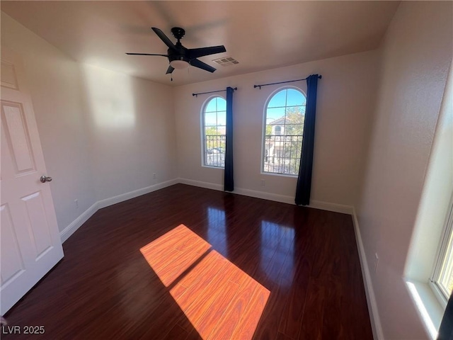 unfurnished room with visible vents, baseboards, a ceiling fan, and wood finished floors