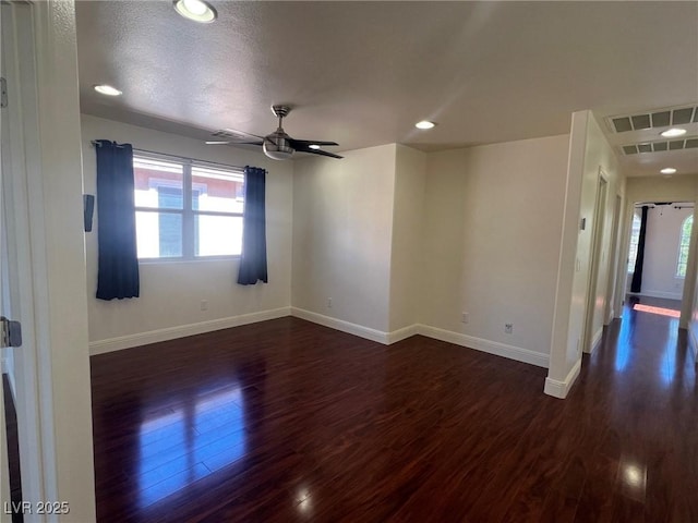 unfurnished room with a wealth of natural light, visible vents, and baseboards