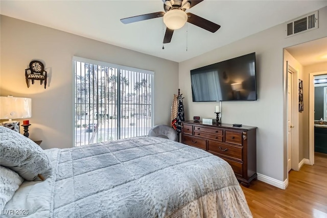 bedroom featuring ensuite bath, wood-type flooring, and ceiling fan