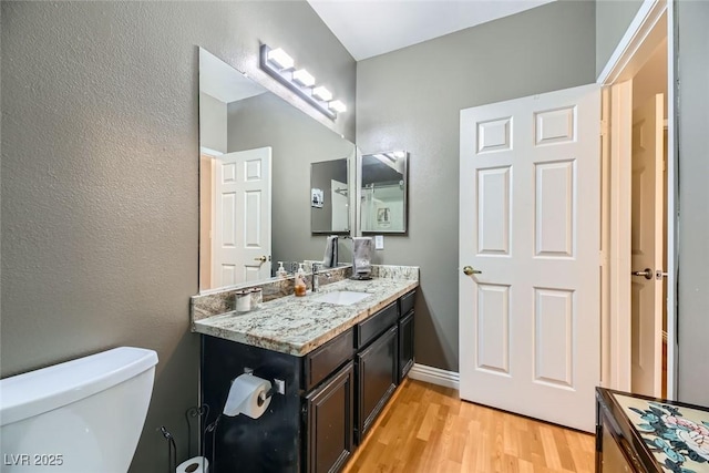 bathroom featuring hardwood / wood-style flooring, vanity, and toilet