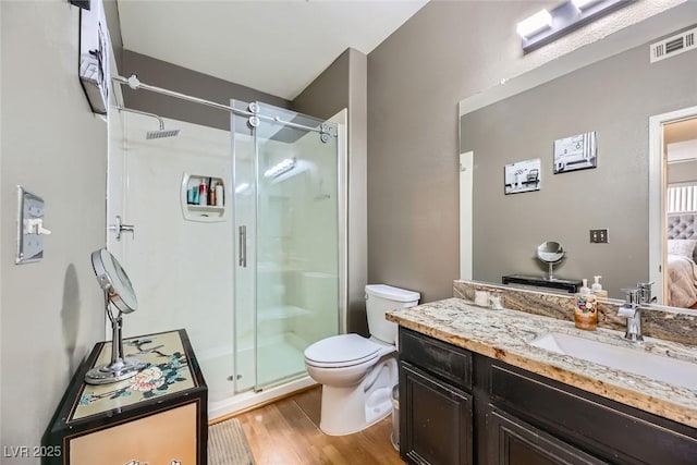 bathroom with vanity, an enclosed shower, hardwood / wood-style flooring, and toilet