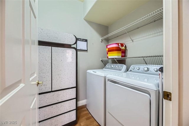 laundry room with separate washer and dryer and hardwood / wood-style flooring