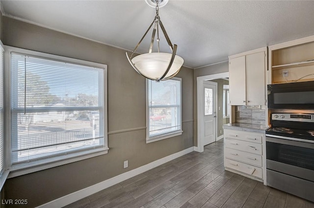 kitchen featuring stainless steel electric range, hanging light fixtures, a wealth of natural light, white cabinets, and dark hardwood / wood-style flooring