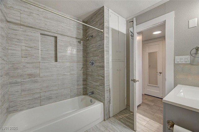 bathroom with vanity, tiled shower / bath combo, and a textured ceiling