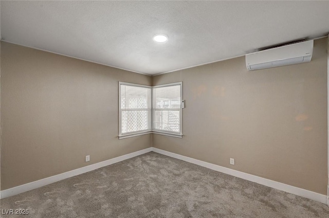 unfurnished room with carpet floors, a textured ceiling, and a wall unit AC