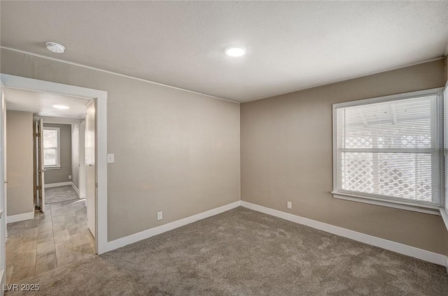 carpeted empty room with a textured ceiling