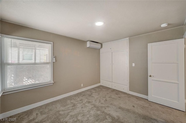 unfurnished bedroom featuring light colored carpet, a closet, and an AC wall unit