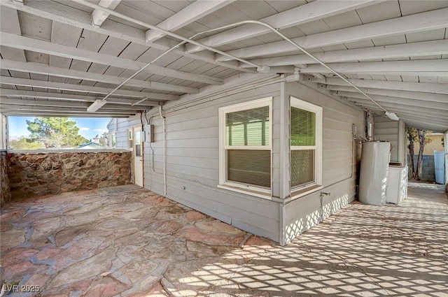 view of side of property featuring a patio and water heater