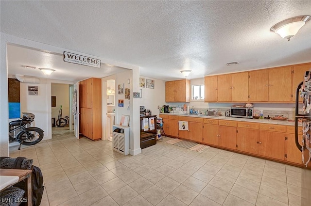 kitchen featuring light tile patterned floors and a textured ceiling