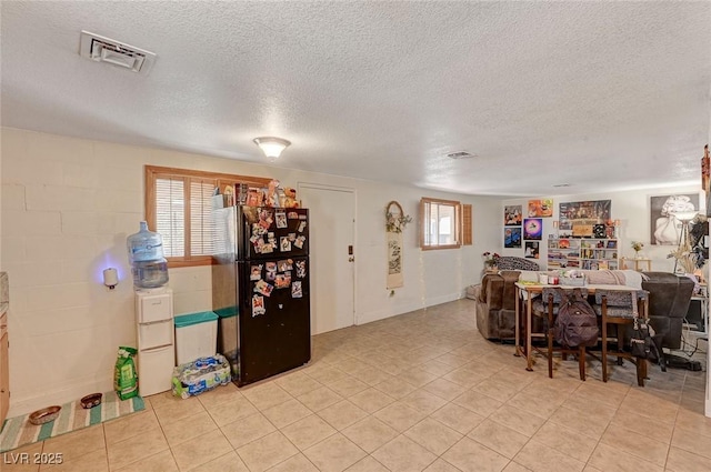 dining area with a healthy amount of sunlight, a textured ceiling, and light tile patterned floors