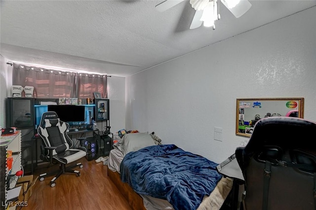 bedroom featuring hardwood / wood-style flooring, ceiling fan, and a textured ceiling