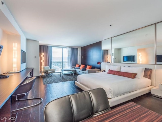 bedroom featuring floor to ceiling windows and dark hardwood / wood-style floors