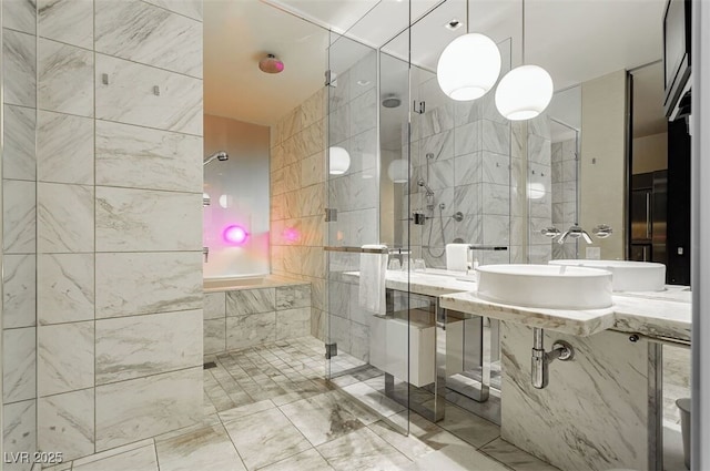 bathroom featuring a shower with shower door, sink, and tile walls