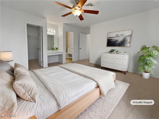 bedroom featuring ensuite bathroom, a walk in closet, ceiling fan, and a closet