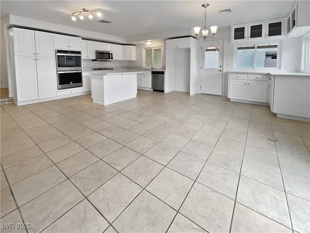 kitchen featuring sink, decorative light fixtures, stainless steel appliances, and white cabinets