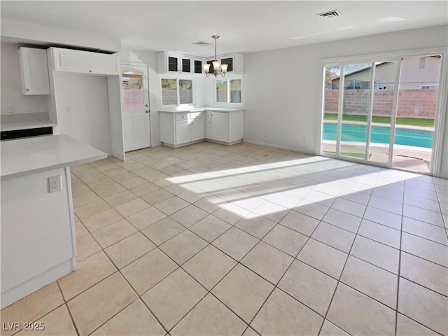 kitchen featuring white cabinetry, decorative light fixtures, light tile patterned flooring, and an inviting chandelier