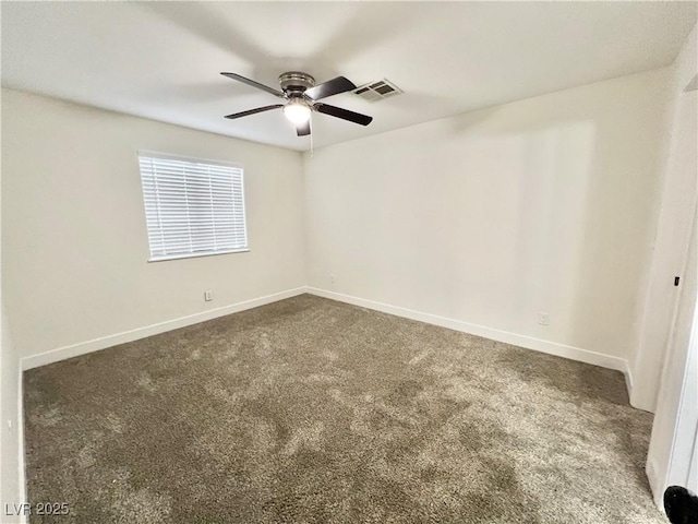 empty room featuring ceiling fan and dark colored carpet