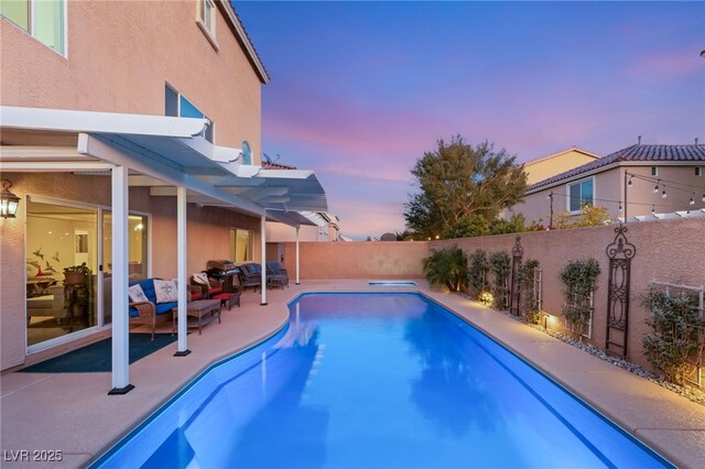 pool at dusk with a patio