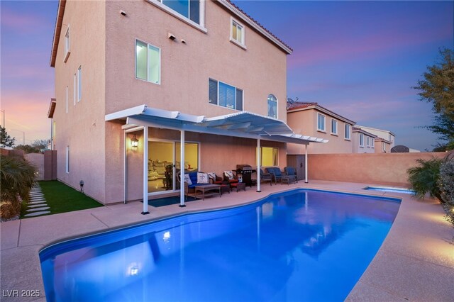 pool at dusk featuring a patio, outdoor lounge area, and a pergola