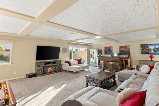 living area featuring visible vents, baseboards, carpet, and a glass covered fireplace