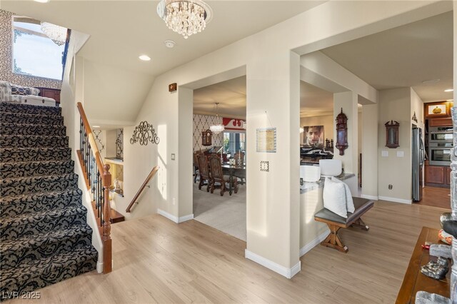 stairs featuring an inviting chandelier and wood-type flooring