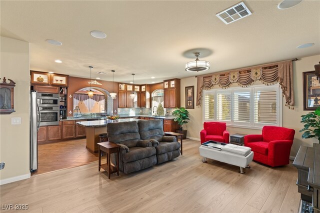 living room featuring sink and light hardwood / wood-style flooring