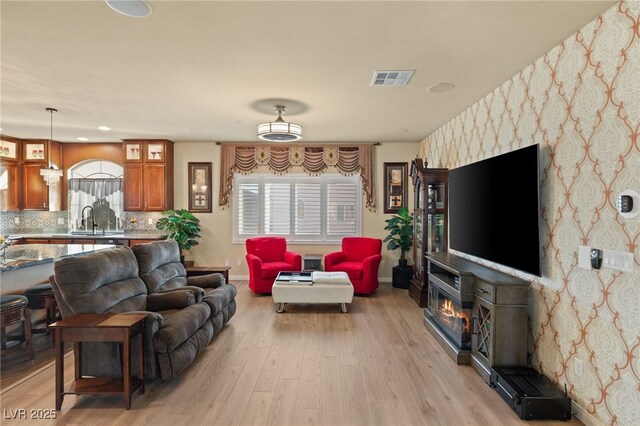 living room featuring sink and light hardwood / wood-style flooring