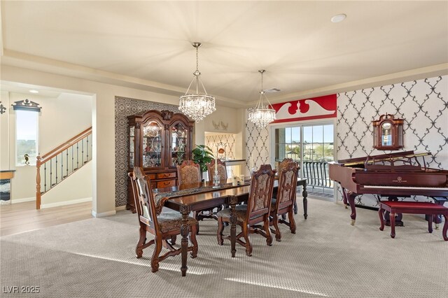 dining area featuring a notable chandelier, stairway, carpet, wallpapered walls, and baseboards