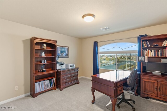 office area with visible vents, light carpet, and baseboards