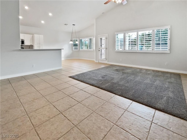 unfurnished living room featuring ceiling fan, high vaulted ceiling, and light tile patterned floors