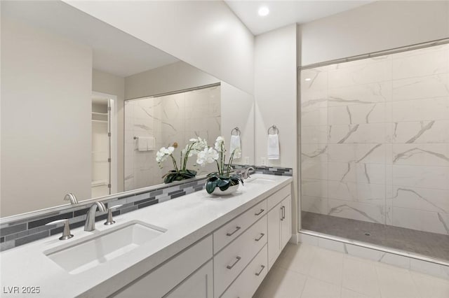 bathroom featuring a tile shower, vanity, decorative backsplash, and tile patterned flooring