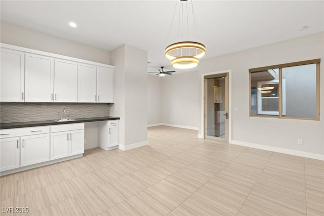 kitchen featuring pendant lighting, sink, ceiling fan, backsplash, and white cabinets