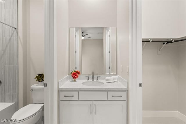 bathroom with walk in shower, ceiling fan, vanity, and toilet