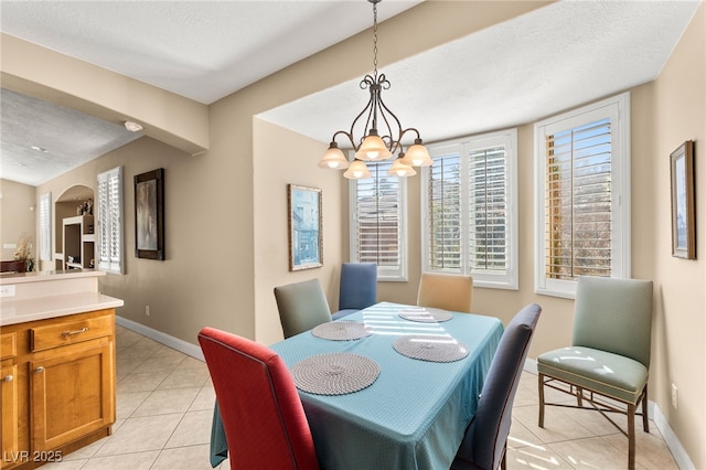 dining room featuring light tile patterned flooring, a chandelier, and a textured ceiling