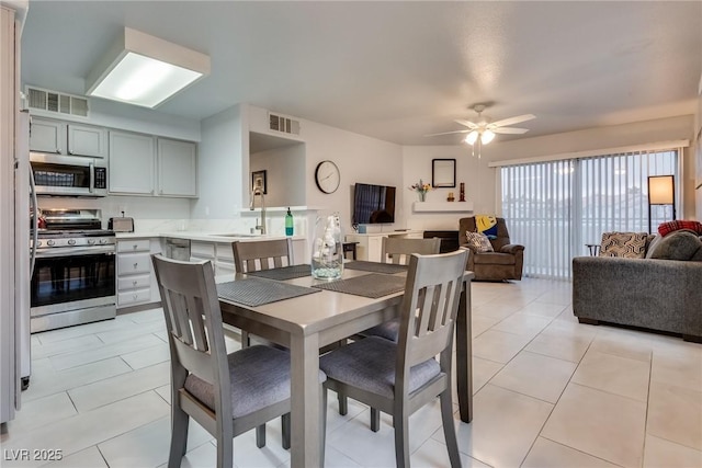 tiled dining area with sink and ceiling fan