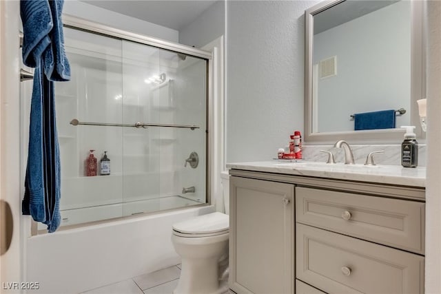 full bathroom featuring vanity, tile patterned flooring, shower / bath combination with glass door, and toilet