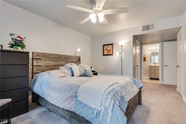 carpeted bedroom with ceiling fan and ensuite bathroom