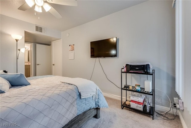 carpeted bedroom with ceiling fan and ensuite bath