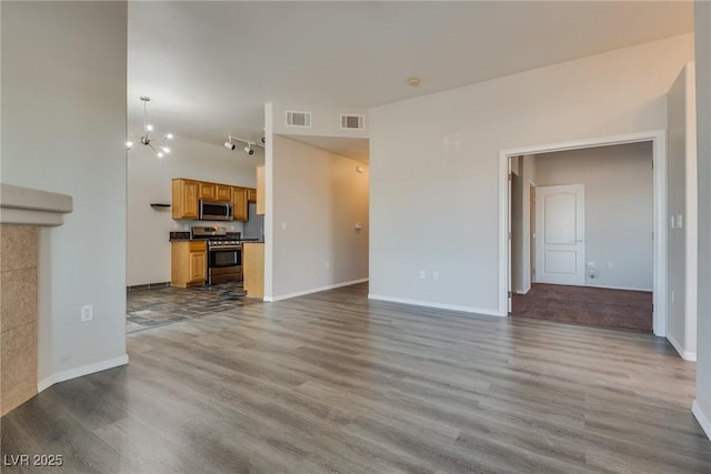 unfurnished living room with an inviting chandelier and light wood-type flooring