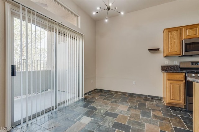 kitchen with an inviting chandelier and stainless steel appliances