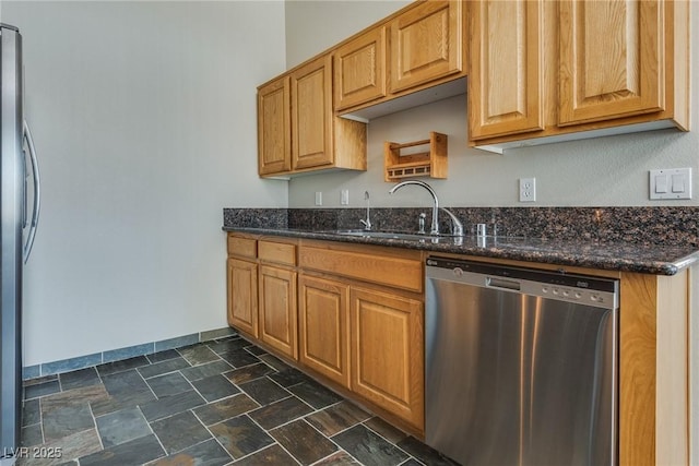 kitchen featuring appliances with stainless steel finishes, sink, and dark stone countertops