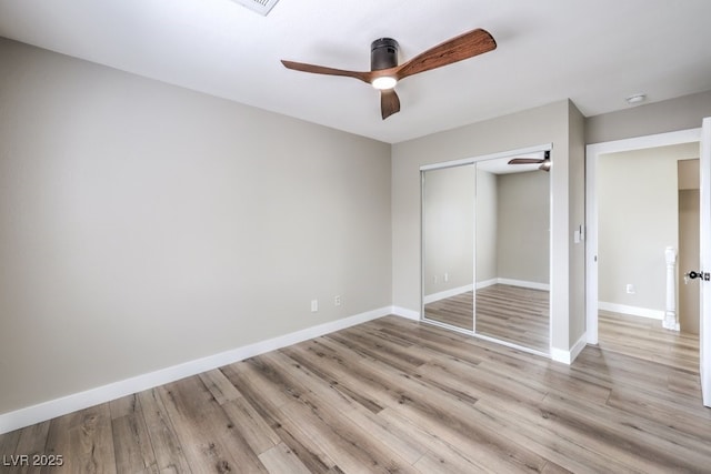 unfurnished bedroom featuring light hardwood / wood-style floors, a closet, and ceiling fan