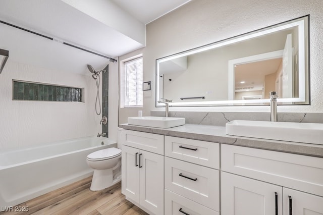 full bathroom featuring vanity, toilet, tiled shower / bath combo, and hardwood / wood-style floors