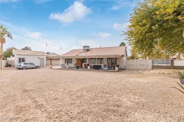 rear view of house with central AC unit and a patio area