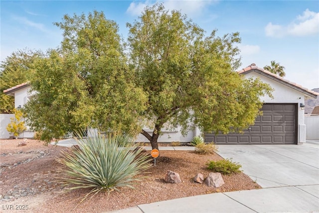 view of property hidden behind natural elements featuring a garage