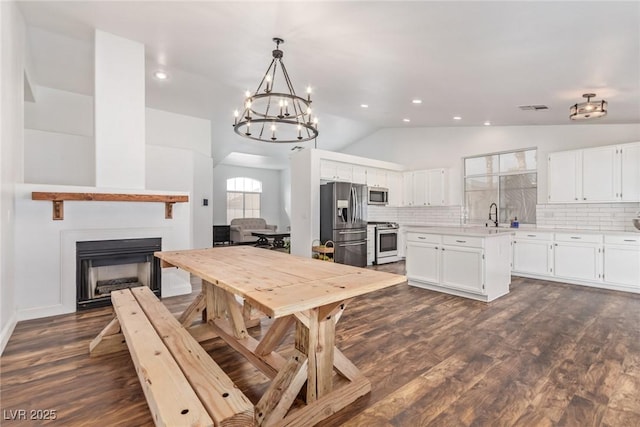 kitchen with white cabinetry, tasteful backsplash, stainless steel appliances, and hanging light fixtures