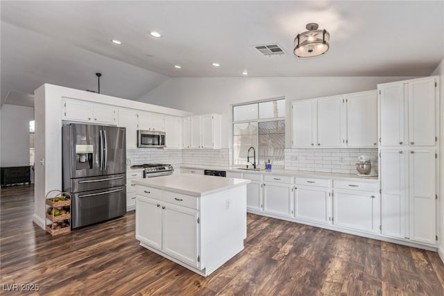 kitchen with decorative backsplash, white cabinets, and appliances with stainless steel finishes