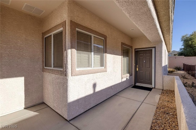 view of exterior entry with a patio