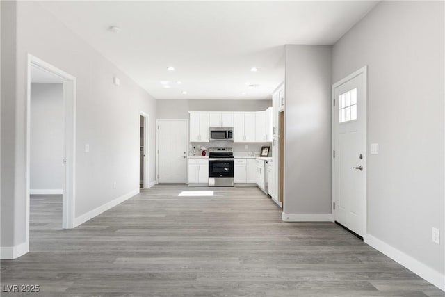 kitchen featuring white cabinetry, appliances with stainless steel finishes, and light hardwood / wood-style flooring