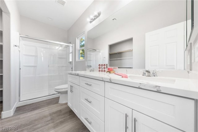 bathroom featuring an enclosed shower, vanity, hardwood / wood-style flooring, and toilet